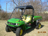 3 Star black soft top installed on a green John Deere Gator HPX/XUV, front three-quarter view in a grass field