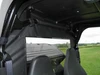 Inside the cab view of the 3 Star soft back panel clear window and top strap on the John Deere Gator roll cage