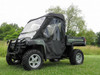 3 Star full cab enclosure installed on a green John Deere Gator XUV with brush guard, front three-quarter view