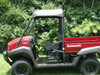 Side profile of a red Kawasaki Mule wearing the 3 Star soft top, parked on grass