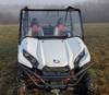 3 Star one-piece clear windshield installed on a white Kawasaki Teryx, front view in a foggy field