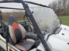 Inside the Teryx cab looking at the 3 Star windshield edge clamped to the cage beside the red and gray seat