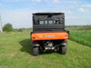 Rear view of an orange Kubota RTV1140 in a field with the 3 Star soft back panel installed behind the cab