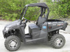Driver side profile of the gray Kymco 450 with the 3 Star soft top installed, front to back view