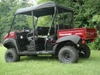 3 Star black soft top installed on a red four-seat side-by-side, side profile in a field