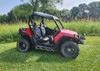 3 Star black soft top on a red Polaris RZR, side view parked on grass with trees behind