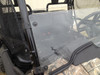 Angled close-up of the Extreme Metal Products half windshield edge and cage clamp on the Honda Pioneer 700 driver side