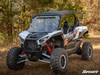 Front three-quarter view of the white Kawasaki Teryx KRX 1000 in the woods with the SuperATV vented windshield
