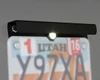 ATV-Tek license plate bracket with LED plate light lit over a mounted license plate, close-up at night