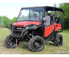 SuperATV 3-inch lift kit installed on a red Honda Pioneer 1000 with mud tires, front three-quarter view