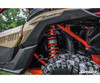 Close-up of the rear shock with the SuperATV lift spacer installed on the tan and red Can-Am Maverick X3