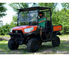 SuperATV 2 inch lift kit installed on an orange Kubota RTV X Series with roof, driven on a grass trail