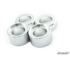 Four machined aluminum spacers from the SuperATV Kubota RTV X Series 2 inch lift kit on white