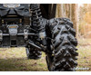 Close-up of the Maverick Trail rear shock with the SuperATV lift spacer installed beside a mud tire