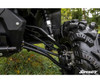 Close-up of the lifted front suspension with SuperATV lift kit A-arms and shock behind a mud tire on the Defender