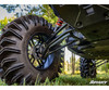 Low-angle close-up of a mud tire and SuperATV lift kit front A-arms under a lifted Can-Am Commander