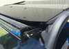 Close-up of an LED light bar bracket at the front edge of the Extreme Metal Products aluminum top over the windshield