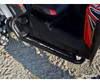 Close-up of the SuperATV heavy-duty nerf bar mounted on a red CFMoto ZForce rocker, parked on gravel