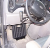 Sure Grip gas and brake guard mounted on the floor of a car in front of the pedals below the steering wheel