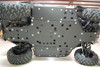 Side view of a Can-Am Commander on a lift showing the Trail Armor full UHMW skid plate with integrated slider nerfs