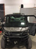 Universal Parts LED light bar mounted above the windshield of a gray Can-Am Defender with full cab, front view in a shop