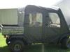 Side view of the 3 Star soft doors with clear windows on a camo Kawasaki Mule 3000/3010 Trans beside a barn