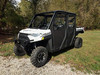 Side X Side soft doors with clear windows installed on a white Polaris Ranger Crew XP 1000, front three-quarter on gravel