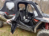 Side X Side soft upper doors on a Polaris RZR XP4 1000 with the front door held open by hand, side view