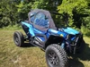Wider front three-quarter view of the blue Polaris RZR Turbo S with Side X Side upper doors on a grassy field