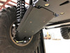 A-arm guard installed on a rear arm of the Wolverine RMAX2 below the coil-over shock, view from the side