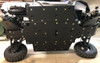 Side view of the Wolverine RMAX2 raised on a lift showing the full Trail Armor skid plate along the underside