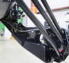 Trail Armor trailing arm guard installed on the Can-Am Maverick X3 rear suspension, viewed from behind the wheel well