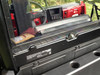 Close-up of the Extreme Metal Products rear window lower edge and mounting bolt above the cargo bed panel