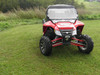 Front view of a red Arctic Cat Wildcat with the 3 Star two-piece scratch-resistant windshield and roof on grass