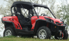 Passenger side view of a red Can-Am Commander with the 3 Star black soft top installed, parked on grass