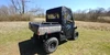 Rear three-quarter view of the 3 Star rear window panel and soft doors on a Hisun Sector with camo cargo bed