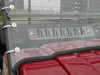 Close-up of the vent slot and clamp hardware at the base of the 3 Star windshield on a red Kawasaki Mule hood