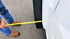 Tape measure showing how far the Trail Armor front mud flap extends past the fender of the white Wolverine RMAX 4