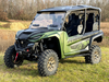 Green four-seat Yamaha RMAX with the Spike Powersports windshield installed, front three-quarter view in a field