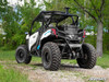 Rear three-quarter view of a white Can-Am Maverick Trail with the SuperATV rear bumper, parked on gravel in the woods