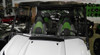 3 Star windshield installed on a white Kawasaki Teryx 750 in a showroom, clear panel with green seats behind, front view