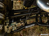 Side close-up of the SuperATV black rear A-arm under the shock of a CF Moto U-Force 1000 on grass