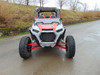 Front view of a red Polaris RZR XP Turbo S on a wet road with the 3 Star half windshield fitted