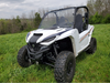 3 Star one-piece scratch-resistant windshield on a white Wolverine RMAX2, front three-quarter view in a grassy field