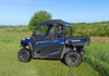 3 Star soft doors and rear window combo on a blue Arctic Cat Stampede, full side view in a green field