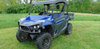 Front view of a blue Arctic Cat Stampede with the 3 Star soft top, wide cropped photo in a field