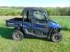 Passenger side profile of a blue Arctic Cat Stampede X with the 3 Star soft doors kit installed, hills behind
