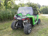 Rear three-quarter view of a green Arctic Cat Wildcat Trail with the 3 Star Lexan rear windshield in a field