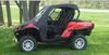 Side view of a red Can-Am Commander with the 3 Star black vinyl top and clear windshield under a tree
