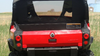 Rear view of the 3 Star clear vinyl rear window with black border above the tailgate of a red Can-Am Commander